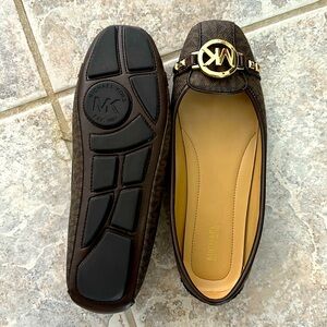 These Michael Kors slip-ons have never been worn, brown with gold accents.